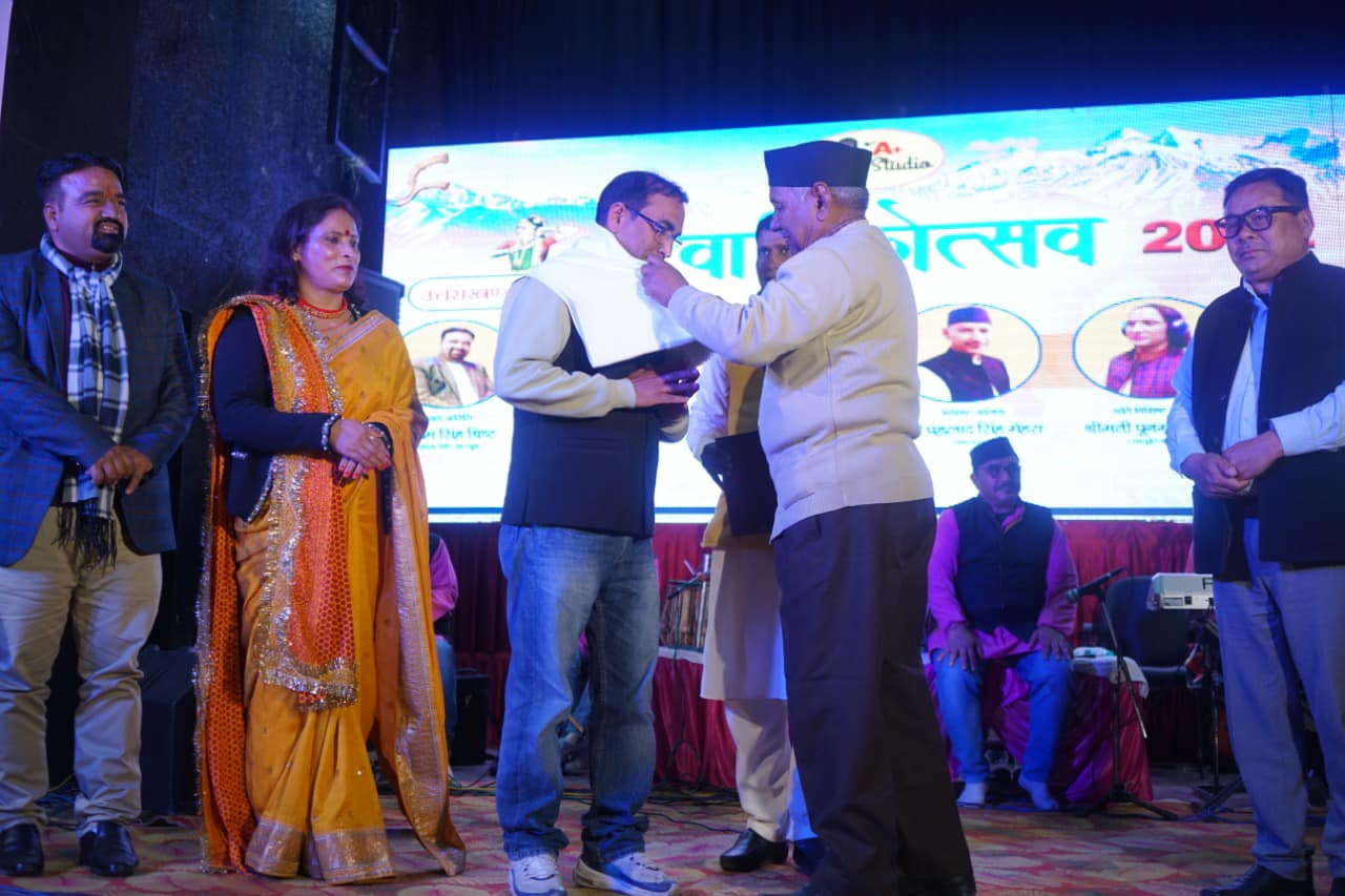 kaman singh topwal is being honoured by narendra singh negi
